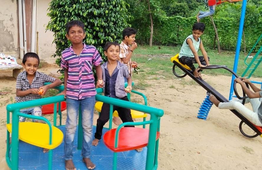 Children using a colorful playground at a partner program in India