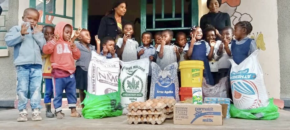 Children and staff in Zambia with food supplies supported by Baal Dan