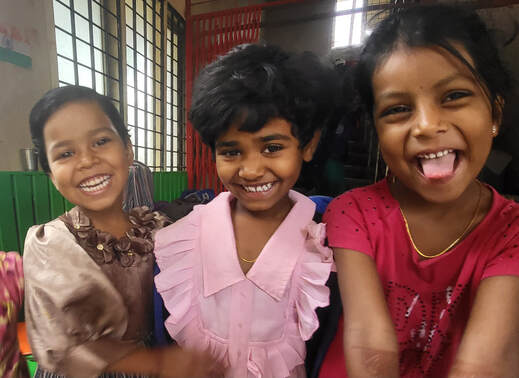 Three girls smiling at a Child Haven International home